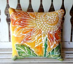 an orange and white pillow sitting on top of a wooden bench