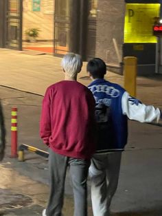 two people walking down the street at night