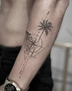 a man's arm with a compass and palm trees on it