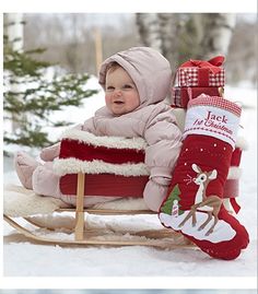 a baby is sitting on a sled in the snow