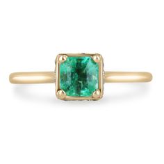 an emerald and diamond ring in yellow gold