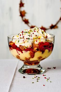 a dessert dish with whipped cream, strawberries and sprinkles