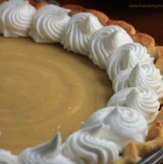 a pie with whipped cream on top sitting on a table