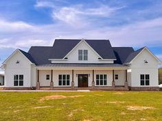 a large white house sitting on top of a lush green field