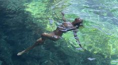 a woman swimming in the water with green algae