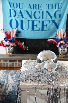 a disco ball sitting on top of a table in front of a sign that says you are the dancing queen