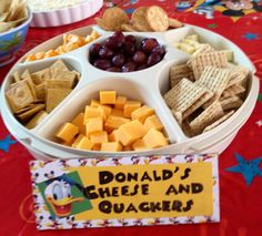 a tray filled with crackers, cheese and grapes