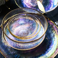 there are four plates stacked on top of each other with gold rims and purple designs