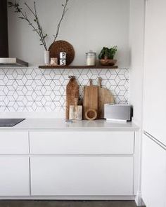 a kitchen with white cabinets and tile backsplashes on the wall above it