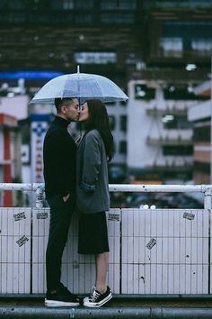 a man and woman kissing under an umbrella