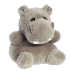 a stuffed hippo laying down with its eyes closed