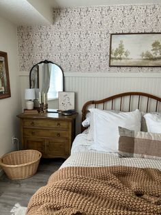 a bed sitting in a bedroom next to a dresser with a mirror on top of it