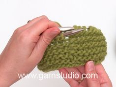 someone is crocheting the side of a green piece of yarn with scissors in their hands