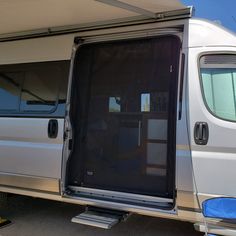 an open door on the side of a white van with it's windows closed