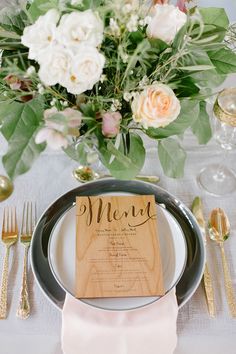 a table setting with flowers and menu cards