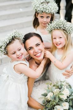 three girls in white dresses and flower crowns on their heads are posing for the camera