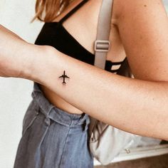 a woman with a small airplane tattoo on her arm