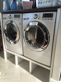 a washer and dryer sitting next to each other in a room with white tile flooring