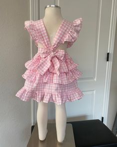 This darling all cotton pink gingham pinafore dress offers loads of ruffles in Carolina Gingham fabric from Robert Kaufman so it's premium cotton and breathable to feel great in the summertime. As is custom with Playful Princess items, the design has our signature flexible fit without fasteners and zippers that may break over time. Adjustable straps loop through the back to tie in a sweet bow. Throw it on over a shirt for a vintage pinafore look during any season. Cute Ruffled Strap Dresses For Picnic, Gingham Dresses With Ruffles For Picnic, Gingham Dress With Ruffles For Picnic, Picnic Gingham Dress With Ruffles, Gingham Dress With Ruffled Hem And Straps, Sweet Gingham Dress With Ruffles, Plaid Ruffled Dress For Picnic, Gingham Dress With Ruffled Straps And Details, Gingham Dress With Ruffled Straps And Ruffles