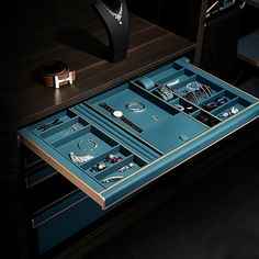 an open drawer with jewelry in it on a table