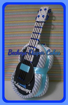 a small guitar shaped cake sitting on top of a blue and white striped table cloth