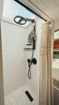 a bathroom with a shower head and hand held shower faucet next to a window