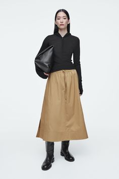 This effortless midi skirt is crafted from cotton-poplin and cut in a flowy, A-line silhouette. It features a drawstring tie that cinches the waist, side slits and a buttoned welt pocket at the back. The rich caramel tone will act as a neutral in your wardrobe. Relaxed fitSide-seam pockets Shell: 100% Cotton. Excluding trims / Machine wash Back length of size 6 is 30.07" / Model wears a size 6 Skirts Diy, Modern Corset, Diy Corset, Belted Cape, Sewing Patterns Skirt, Skirt Circle, Skirt Patterns, Handmade Skirts, Pattern Skirt