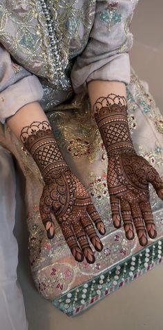 a woman's hands with hennap on her hand and the bottom half of her arm