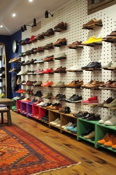 there are many pairs of shoes on the wall in this shoe store that is filled with people's footwear