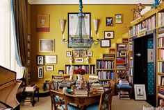 a living room filled with lots of furniture and bookshelves next to a piano