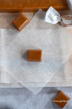 two pieces of caramel sitting on top of wax paper