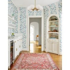 an ornate rug in the middle of a room with blue and red wallpaper on it