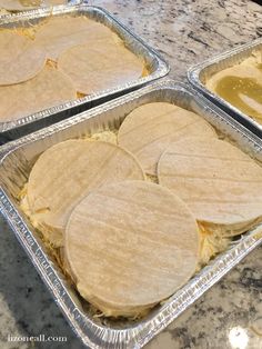 three pans filled with tortillas sitting on top of a counter