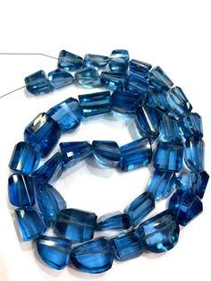 a strand of blue glass beads on a white surface