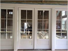 two white doors with glass panes on the side of a building under construction in front of them