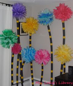 some colorful pom poms are hanging on the wall