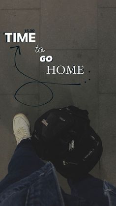 a person with their feet on the ground next to a backpack and hat that says time to go home