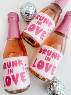 three bottles of pink wine with the words drunk in love on them and disco balls