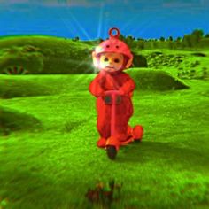 an animated image of a person in a red suit riding a scooter on the grass