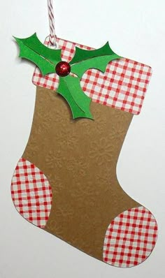 a christmas stocking hanging on a wall with a red and white checkered ribbon