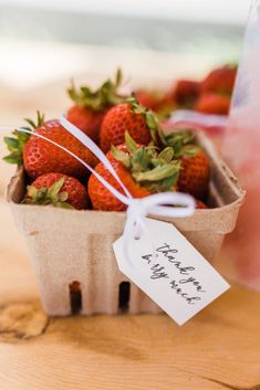 strawberries are in a small basket with a price tag