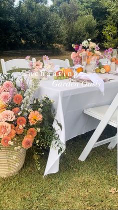 an outdoor table set up with flowers and fruit for a wedding breakfast or bridal party