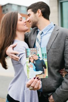 a man and woman kissing each other while holding up a card with an image on it