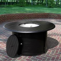 an outdoor fire pit sitting on top of a brick patio