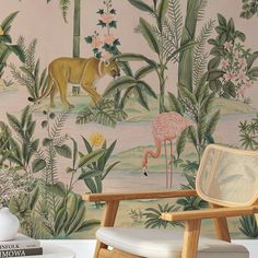 the wallpaper in this room is painted with pink flamingos and palm trees, while an antelope stands next to it