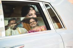 the bride and groom are sitting in their car