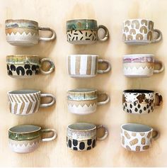 many different cups are lined up on the wall