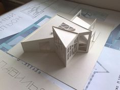 a paper model of a house sitting on top of papers