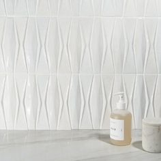 a bottle of liquid sitting on top of a counter next to a container with soap