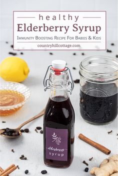 a bottle of elderberry syrup next to some cinnamon sticks